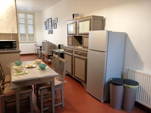 a kitchen with a table and a refrigerator at Chez Louise in Guise
