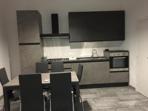 una cucina con tavolo, sedie e fornelli di Pierpa's House o Casa Pierpa a Catania