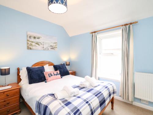 ein Schlafzimmer mit einem Bett und einem Fenster in der Unterkunft Guinea Cottage in Weymouth