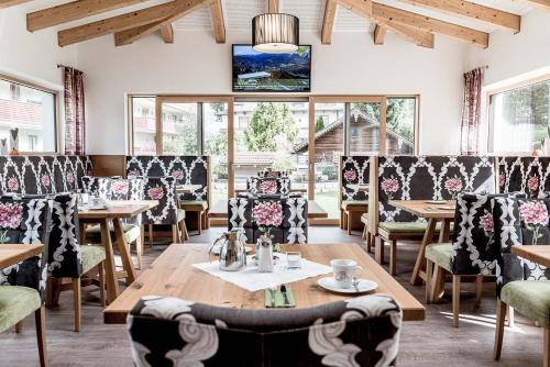 um restaurante com mesas e cadeiras e uma televisão na parede em B&B Hotel DIE BARBARA em Schladming