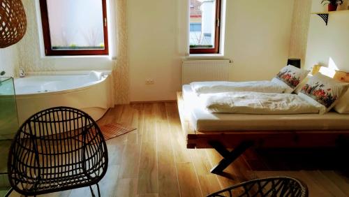 a bathroom with a tub and a couch and a table at Apartmány Cechovní in Moravská Třebová