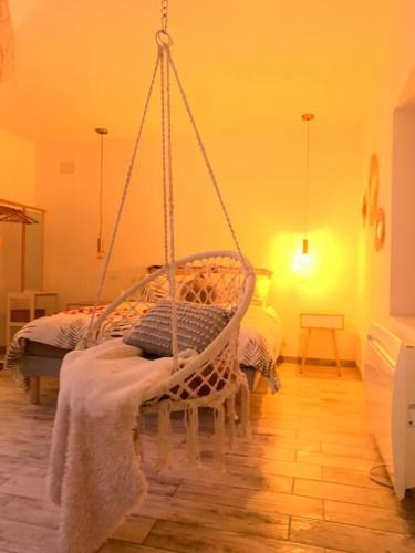 - une balançoire dans une chambre avec un lit dans l'établissement Cottage Interieur Spa classé 4 étoiles - balnéo et sauna privatif, à Tannay