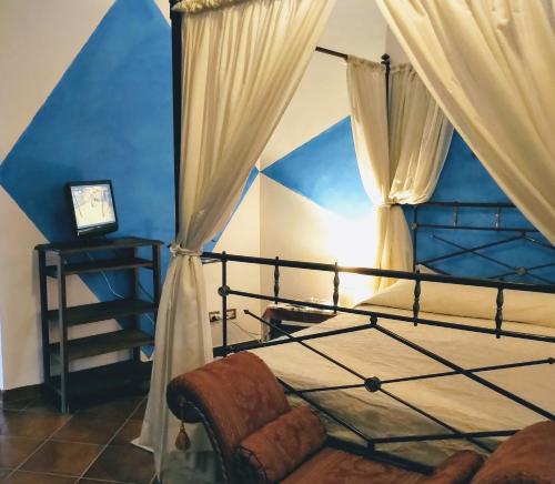 1 dormitorio con cama con dosel y pared azul en Agriturismo Tenuta Monte La Guardia, en Castel Giuliano