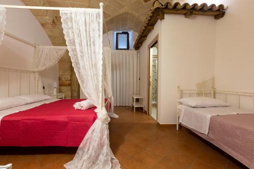 コペルティーノにあるB&B La Uliaのベッドルーム1室(ベッド2台、天蓋付きベッド1台付)