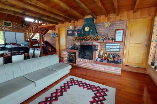 a living room with a couch and a fireplace at Laguna de la Cocha - Cabaña Janaxpacha in Los Alisales
