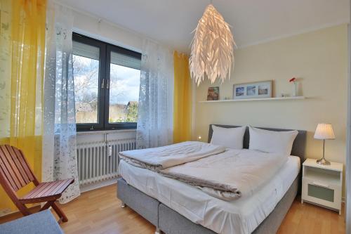 a bedroom with a bed and a chair and a window at Appartementanlage am Taschensee Taschensee Appartement 9 in Gronenberg