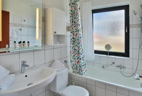 a bathroom with a toilet and a sink and a window at Appartementanlage am Taschensee Taschensee Appartement 9 in Gronenberg