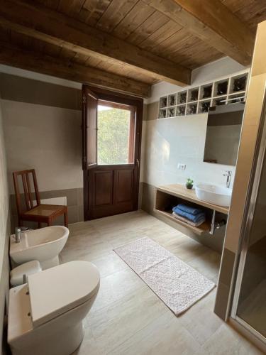 a bathroom with two toilets and a sink at S'Abba Druche rooms in Bosa