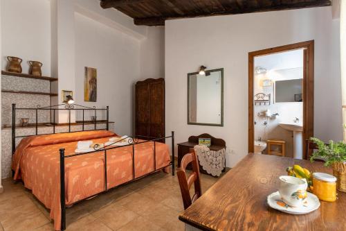 1 dormitorio con cama y mesa de madera en Agriturismo Case Don Ignazio, en Casale Modica