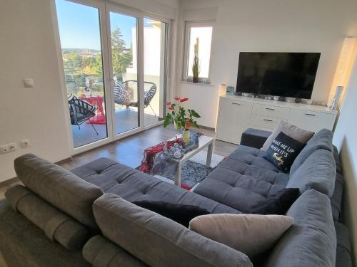uma sala de estar com um sofá e uma televisão em Sea View Medulin Apartment - Orijeta em Medulin