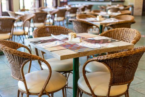 une table avec des chaises en osier dans un restaurant dans l'établissement Villa di Mantova Resort Hotel, à Águas de Lindóia