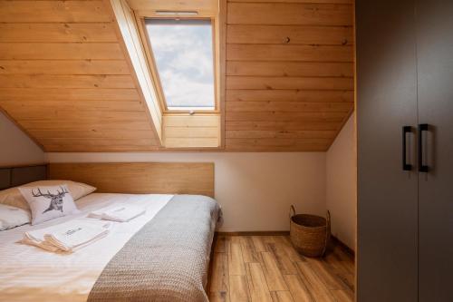 Schlafzimmer mit einem großen Bett und einem Fenster in der Unterkunft Osada Wróblonki - Apartamenty in Wisła