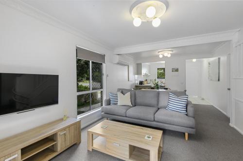 a living room with a gray couch and a large television at 3 40 Bigoon Road in Point Lookout