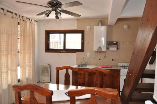 cocina con mesa y ventilador de techo en Yatale II en Chascomús