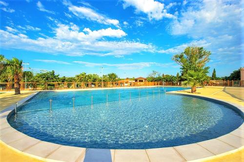 uma grande piscina num parque com um céu azul em MOBIL HOME 4 PERSONNES TOUT CONFORT em Port-la-Nouvelle