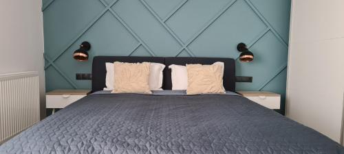 a bedroom with a large bed with blue walls at City Apartment Anton Pann in Cluj-Napoca