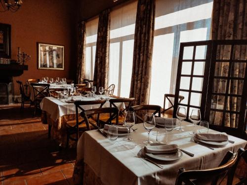 a dining room with tables with white tablecloths and glasses at Posada Real Restaurante El Linar Del Zaire in Burgohondo