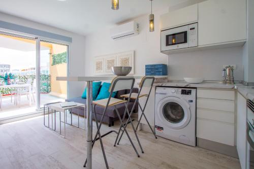 a kitchen with a table and a washing machine at PRIMERISIMA LINEA DE PLAYA - CULLERA BAHIA DE LOS NARANJOS I in Cullera
