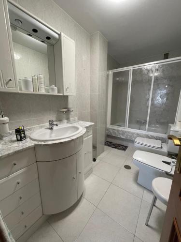 Baño blanco con lavabo y aseo en Oktheway Rua Nova 3D, en Sarria
