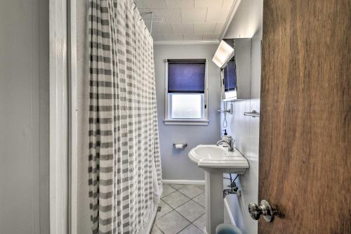 a bathroom with a sink and a shower curtain at Nags Head Cottage Screened Porch, Walk to Beach! in Nags Head