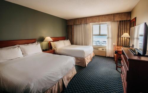 a hotel room with two beds and a television at The Frobisher Inn in Iqaluit