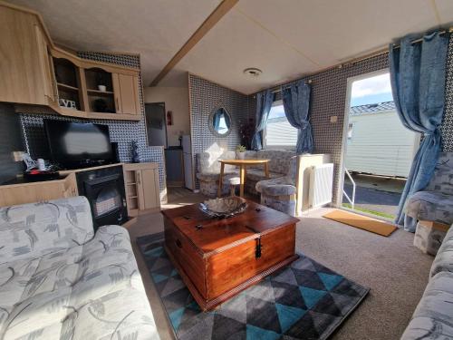 ein Wohnzimmer mit einem Sofa und einem Couchtisch in der Unterkunft Inviting 3-Bed Caravan in Porthcawl in Porthcawl