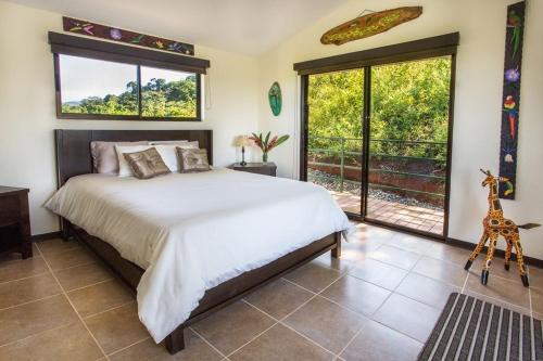 a bedroom with a bed and a large window at Villa Vista Hermosa - with breathtaking ocean view & WiFI in Quepos