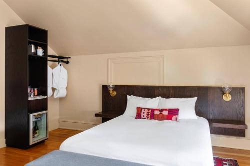 a bedroom with a white bed with a wooden headboard at The Francis Hotel in Portland