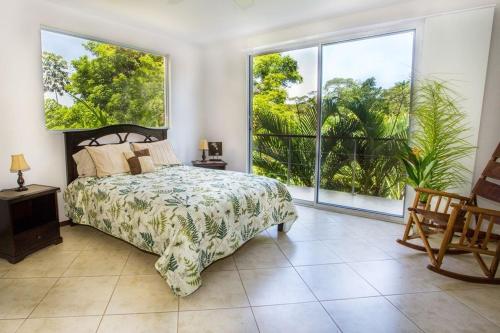 sypialnia z łóżkiem i dużym oknem w obiekcie Casa de Fox - Confort en medio de la jungla! w mieście Manuel Antonio