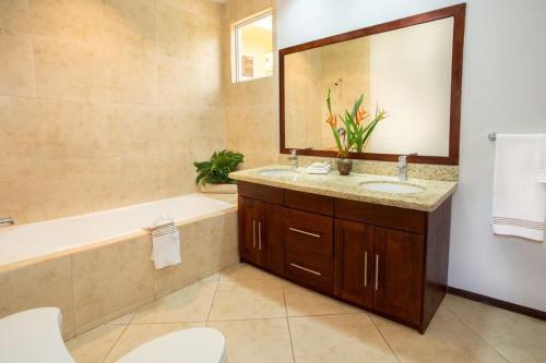 曼努埃爾安東尼奧的住宿－Casa de Fox - Confort en medio de la jungla!，带浴缸、水槽和镜子的浴室