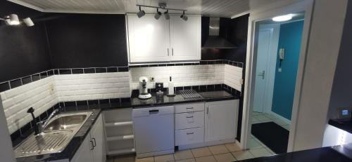 a kitchen with white cabinets and a sink at Résidence Gabrielle centre de Spa in Spa