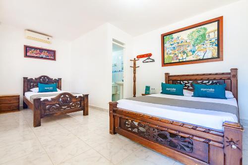 a bedroom with two beds and a picture on the wall at Hotel Colonial La Casa De Siempre in Valledupar