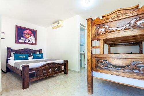 1 dormitorio con 1 cama grande de madera en una habitación en Hotel Colonial La Casa De Siempre, en Valledupar