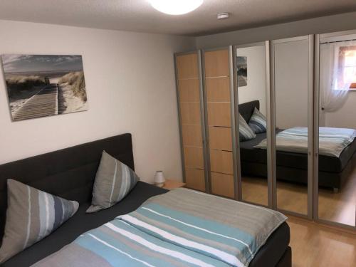 - une chambre avec un lit et un miroir dans l'établissement Ferienwohnung Ruderich, à Hirschaid