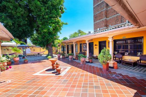 a courtyard with potted plants and a building at Hotel Colonial La Casa De Siempre in Valledupar