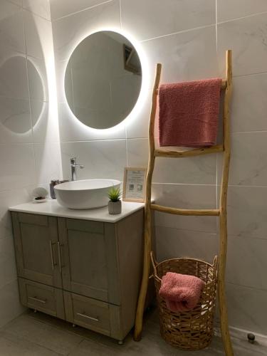 ein Bad mit einem Waschbecken und einem Spiegel in der Unterkunft ''Korifo apartment'' at Benitses in Benitses