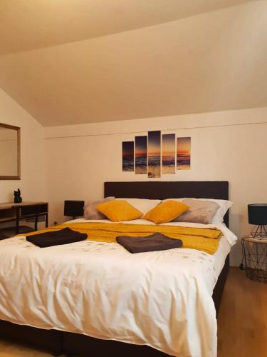 a bedroom with a large white bed with yellow pillows at Villa Mateja in Novalja