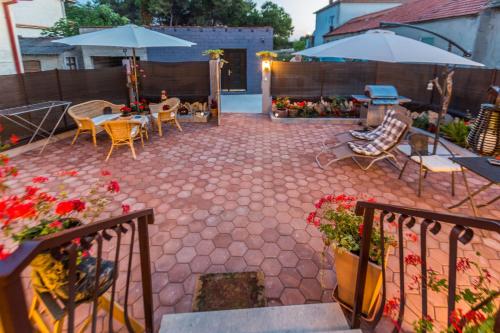 eine Terrasse mit einem Tisch, Stühlen und Sonnenschirmen in der Unterkunft Apartments & Rooms Hosana in Zadar