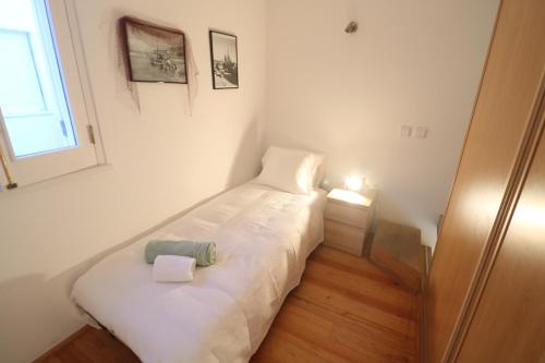 een klein wit bed in een kamer met een raam bij Tiny House in Nazaré