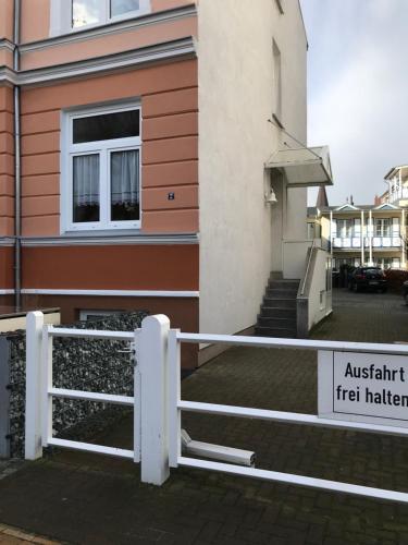 a white fence in front of a building at Meeresbriese Warnemünde in Warnemünde