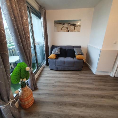 un salon avec un canapé et une grande fenêtre dans l'établissement le studio paradis bleue, à La Grande Motte