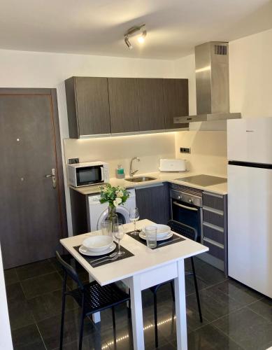 a kitchen with a table with chairs and a refrigerator at Ca_LaGrava in Jávea