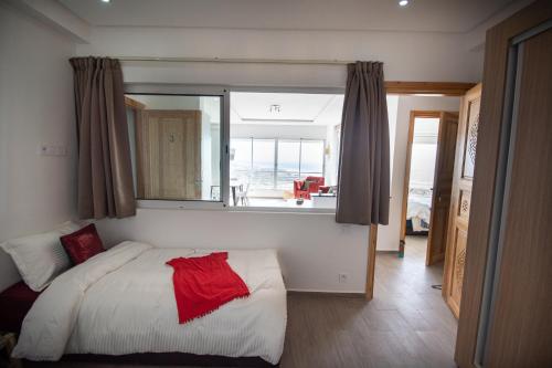a bedroom with a bed and a window with a view of the ocean at NjoY Morocco in Tamraght Ouzdar