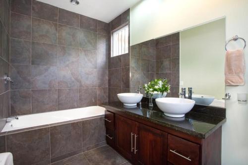 a bathroom with two sinks and a large mirror at Tres Amigos House Luxurious with Jungle and Ocean View in Quepos