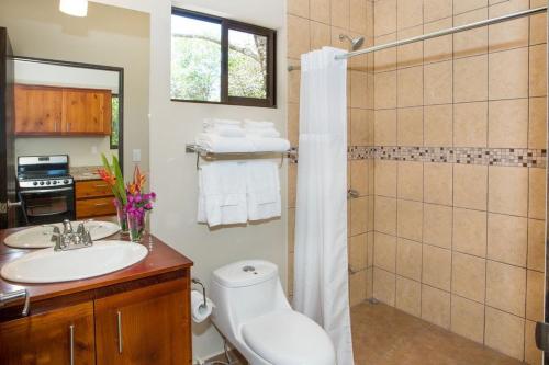 a bathroom with a toilet and a sink and a shower at Villa Iguana - Great place & privacy with Jacuzzi & WiFi in Quepos