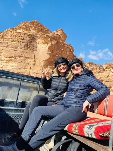 two women sitting on the back of a truck at wadi rum land mars in Wadi Rum