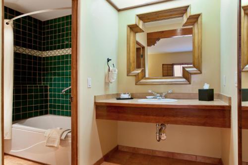 
a bathroom with a tub, sink and mirror at Old Santa Fe Inn in Santa Fe
