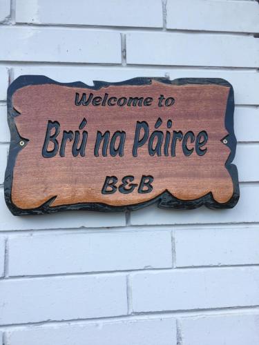 een houten bord aan een stenen muur bij Bru Na Pairc B&B in Bantry