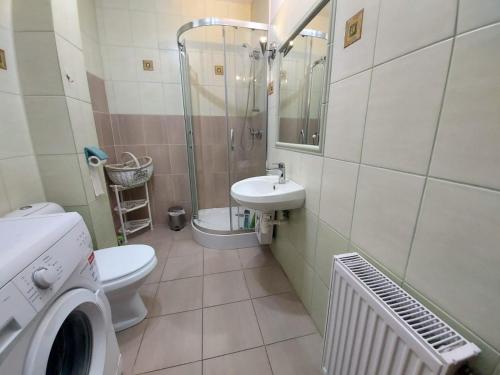 ein Bad mit einem WC, einem Waschbecken und einer Dusche in der Unterkunft Apartament z widokiem na las Na wydmie in Ustka