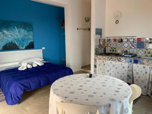 ein Schlafzimmer mit einem Bett und einem Tisch darin in der Unterkunft La casa del vento Stagnone in Marsala